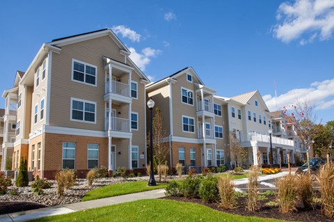 an apartment building with a sidewalk in front of it