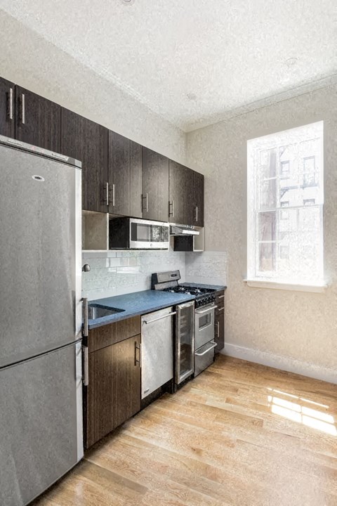 A kitchen with a refrigerator, stove, and oven.