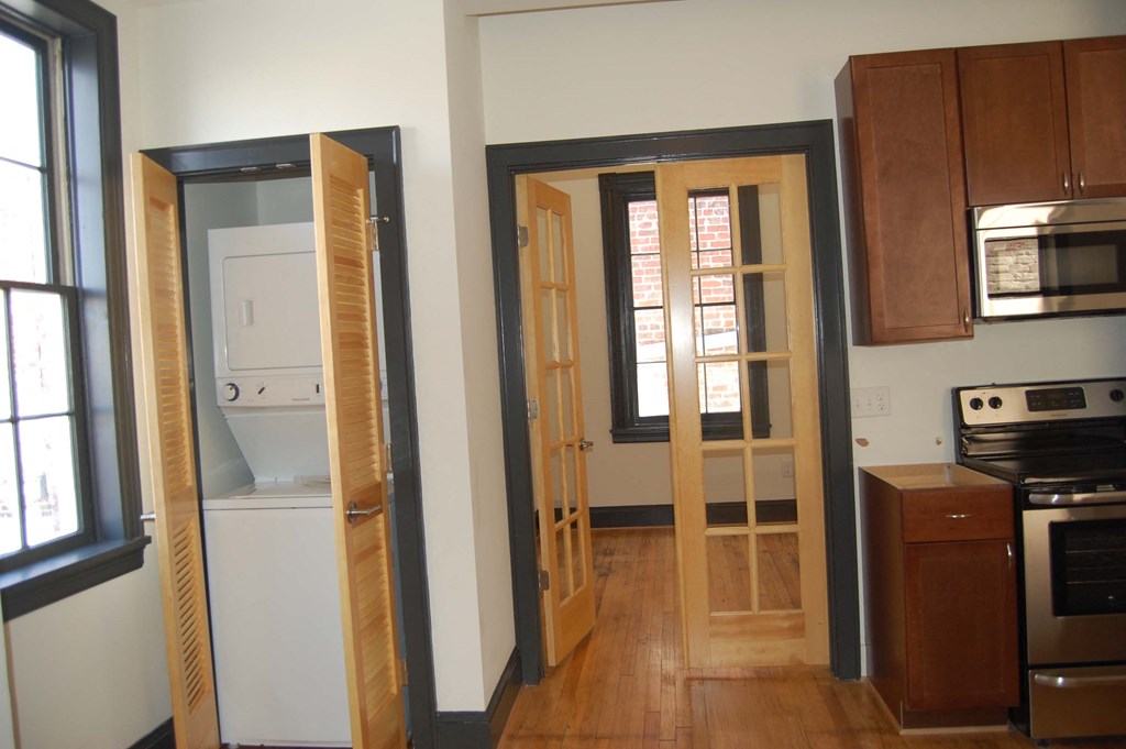 a kitchen with wooden doors and a stove and a refrigerator