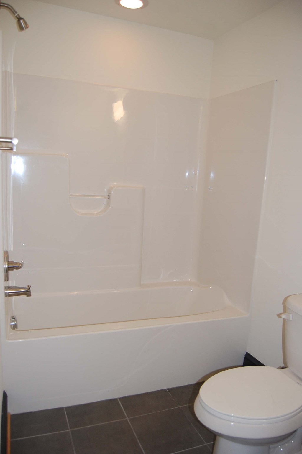 a white bathroom with a toilet and a tub