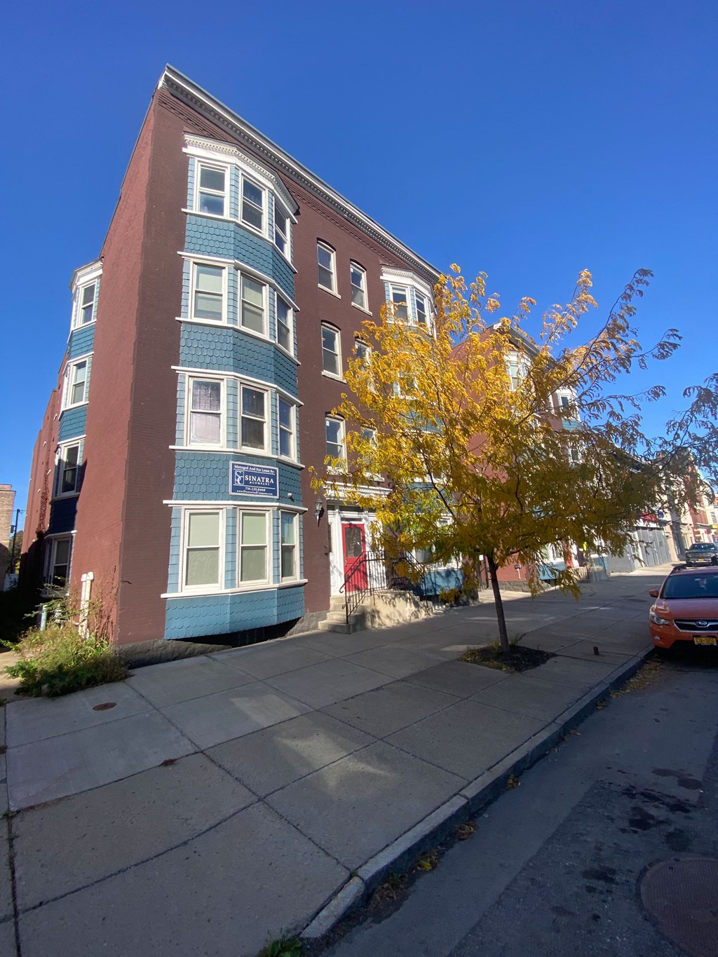 a building on a city street with a tree in front of it