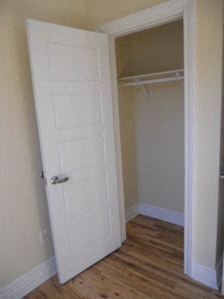 an empty room with a white door to a closet