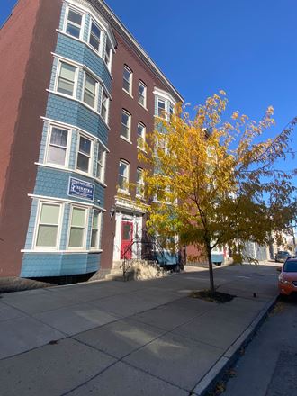 a blue and red building with a tree in front of it