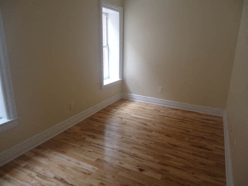 a living room with a wooden floor and a window
