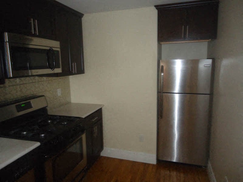 a kitchen with a stainless steel refrigerator and a stove