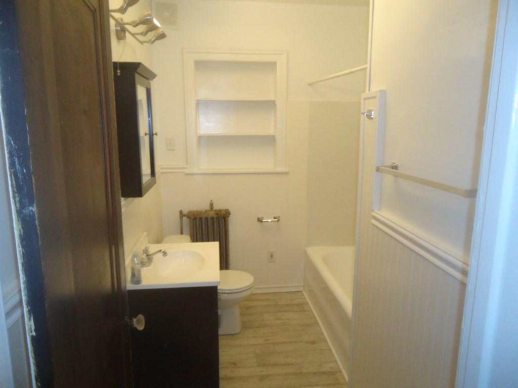 a small bathroom with a sink toilet and bath tub