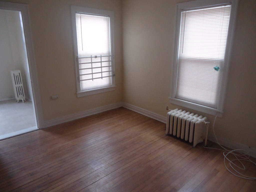 the living room with wood floors and two windows