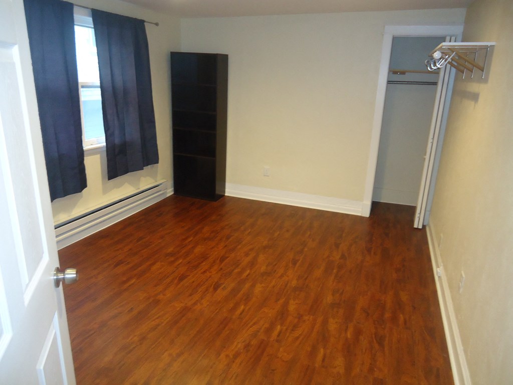 an empty room with wooden floors and a closet