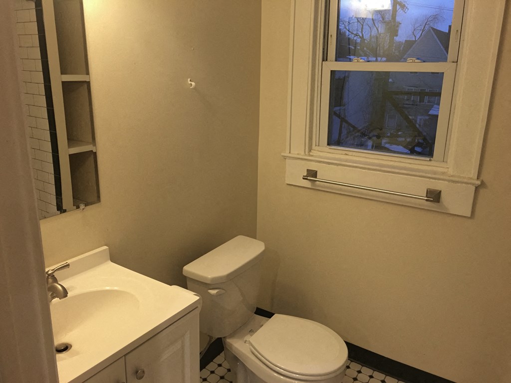 a bathroom with a toilet and a window