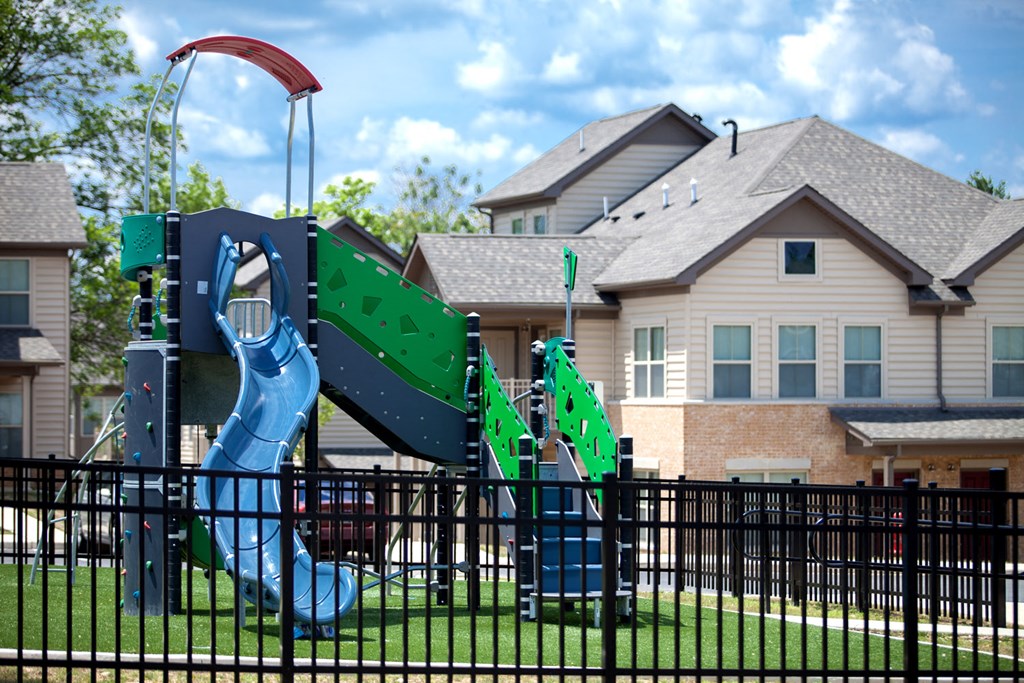 a playground in front of a house with a slide