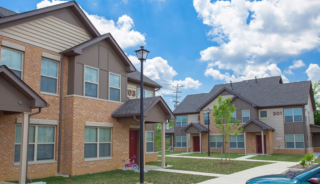 a row of brick apartment buildings with a sidewalk in front of them