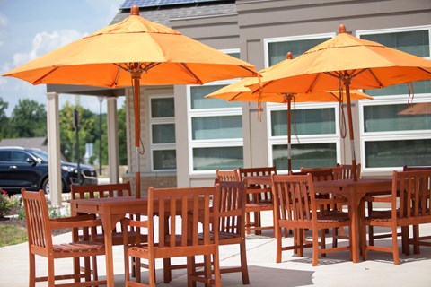 an outdoor patio with orange umbrellas and chairs