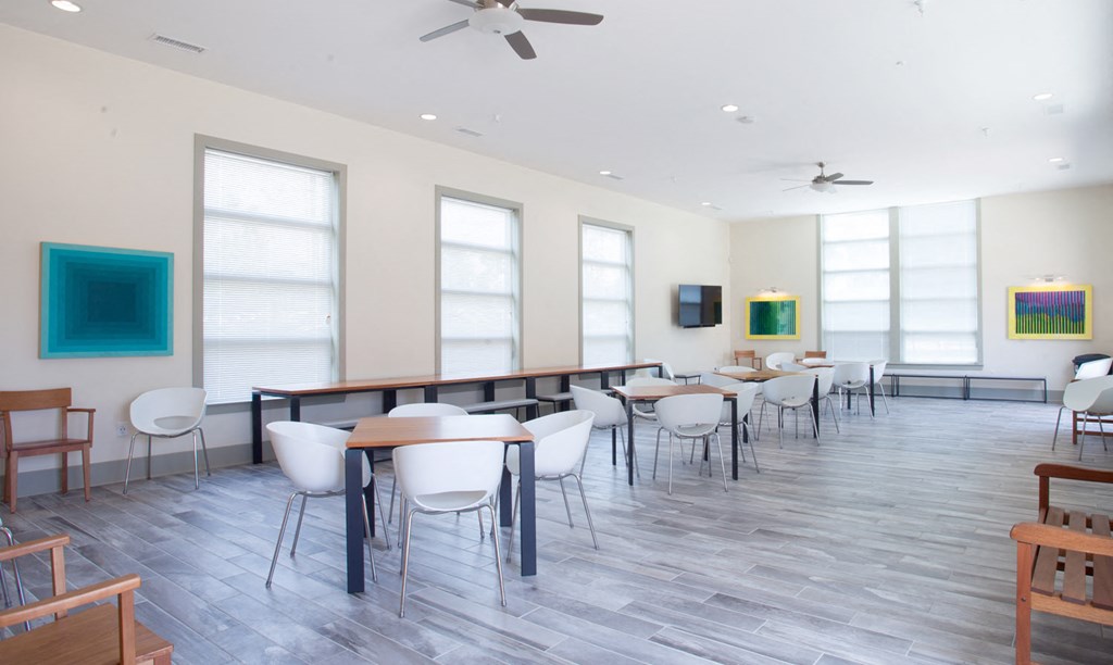 a dining room with tables and chairs in a room with large windows