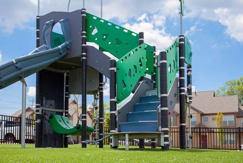a large green playground with a large set of slides