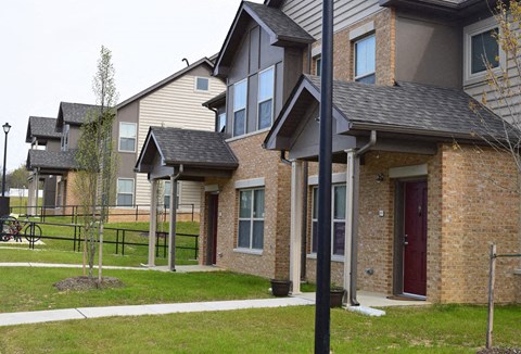a row of houses with a sidewalk and grass