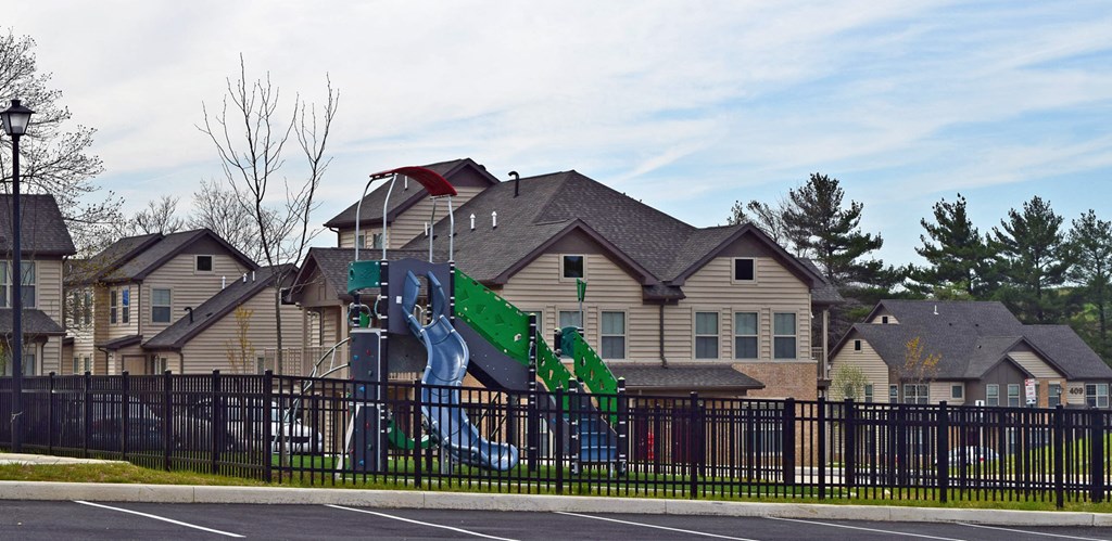 a house with a play set behind a fence