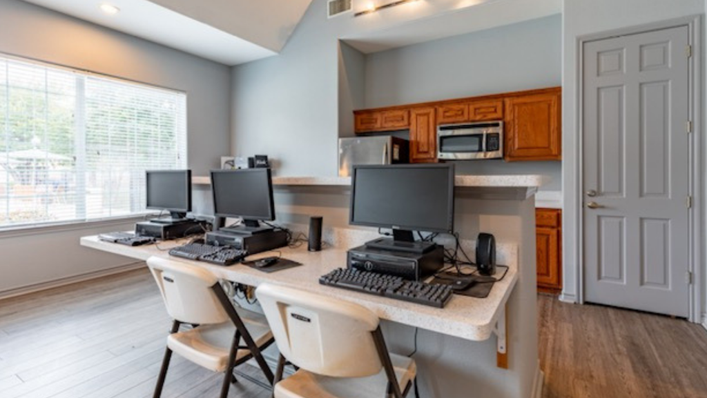 an office with three computers on a desk