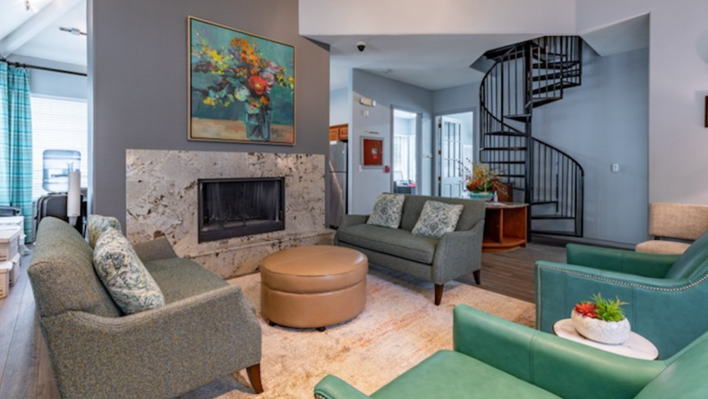 a living room with a fireplace and a spiral staircase