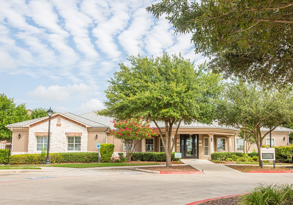 a building with a sign in front of it and trees