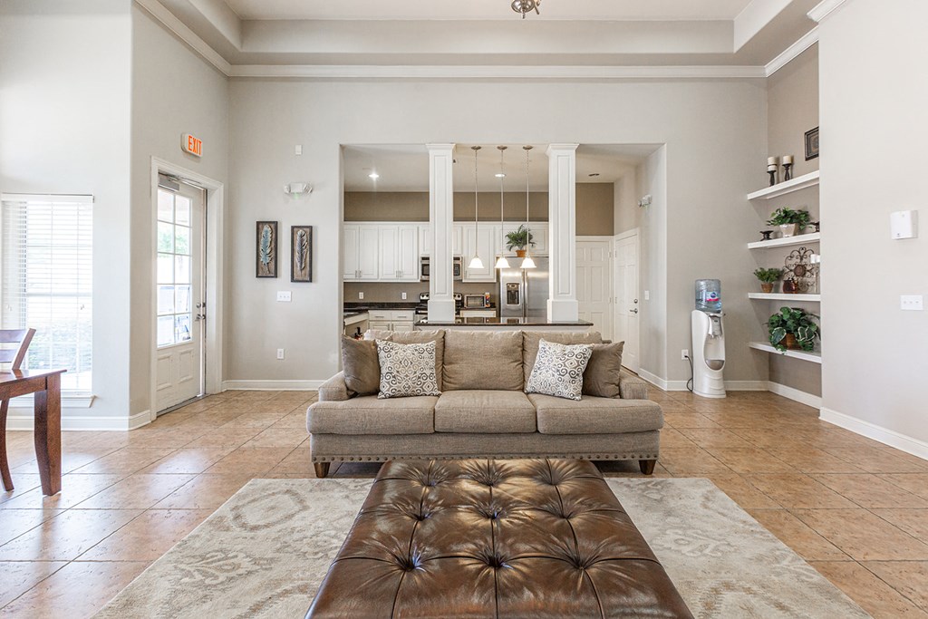 a living room with a couch in front of a kitchen