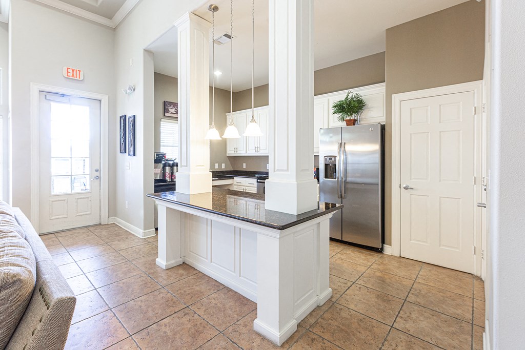 a kitchen with a counter top and a stainless steel refrigerator