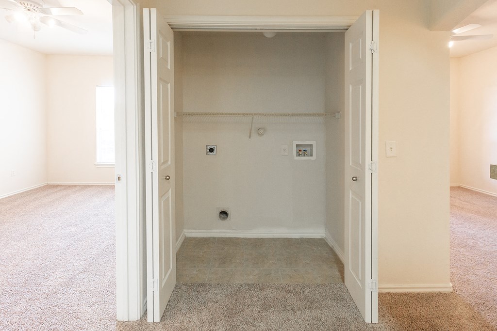 an empty living room with a tiled floor and a shower in the wall