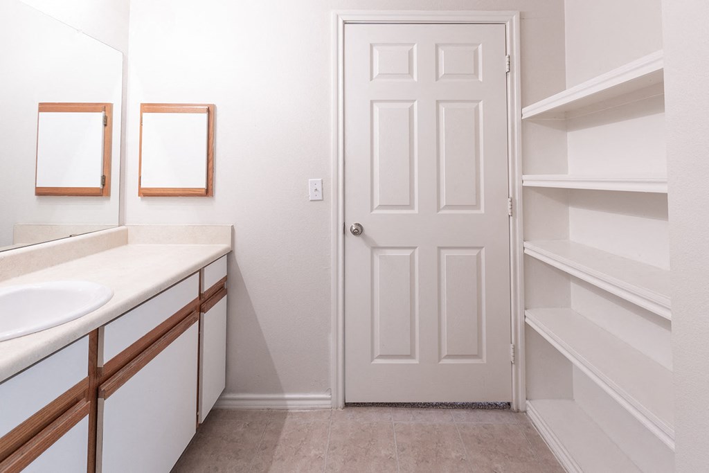 a bathroom with a white door and a sink and a closet