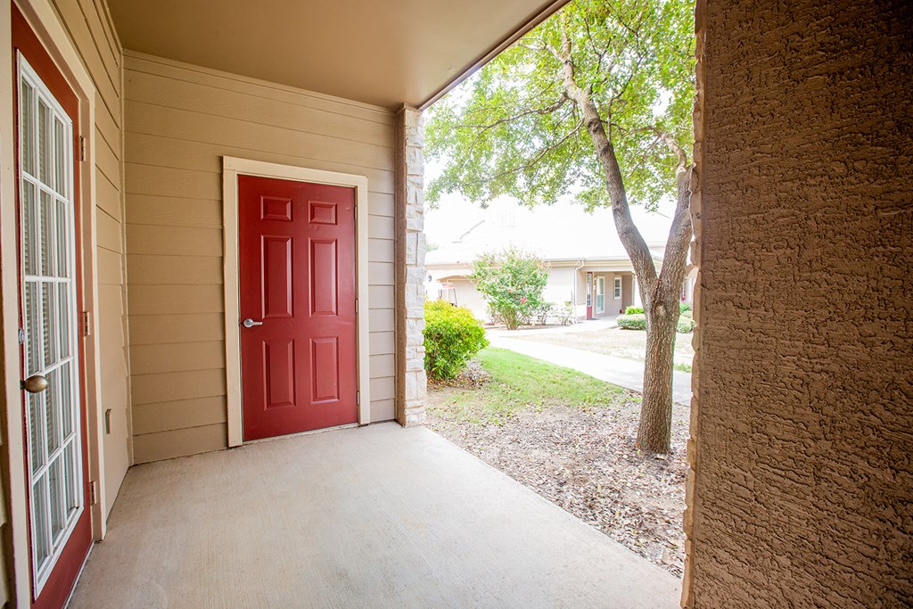 a front porch with a red door on a house