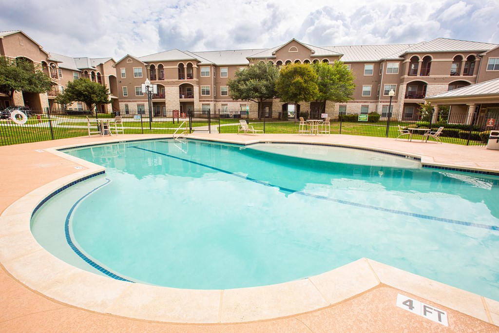 a swimming pool with an apartment building in the background