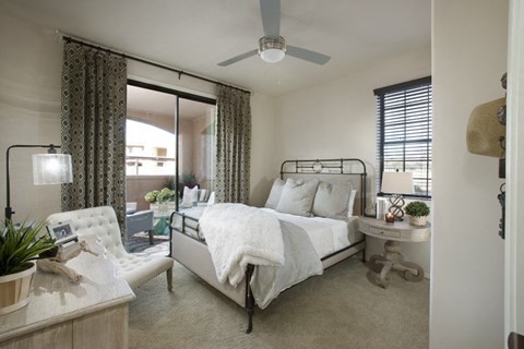 a bedroom with a white bed and a ceiling fan