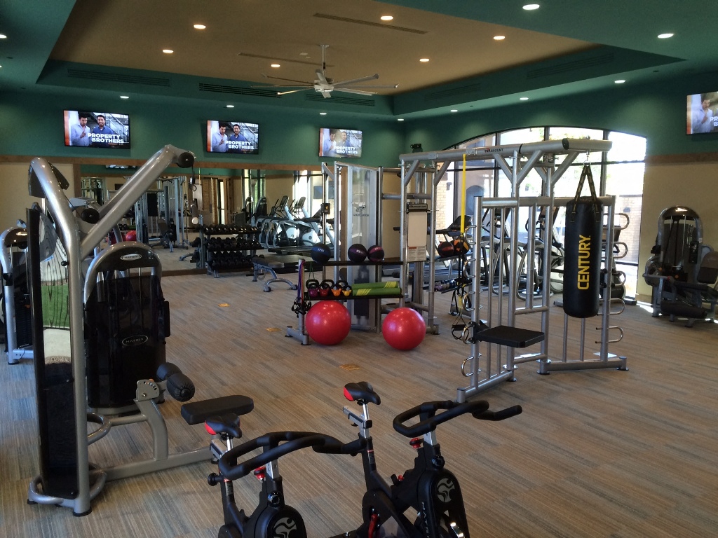 a gym with weights and other exercise equipment on a wooden floor