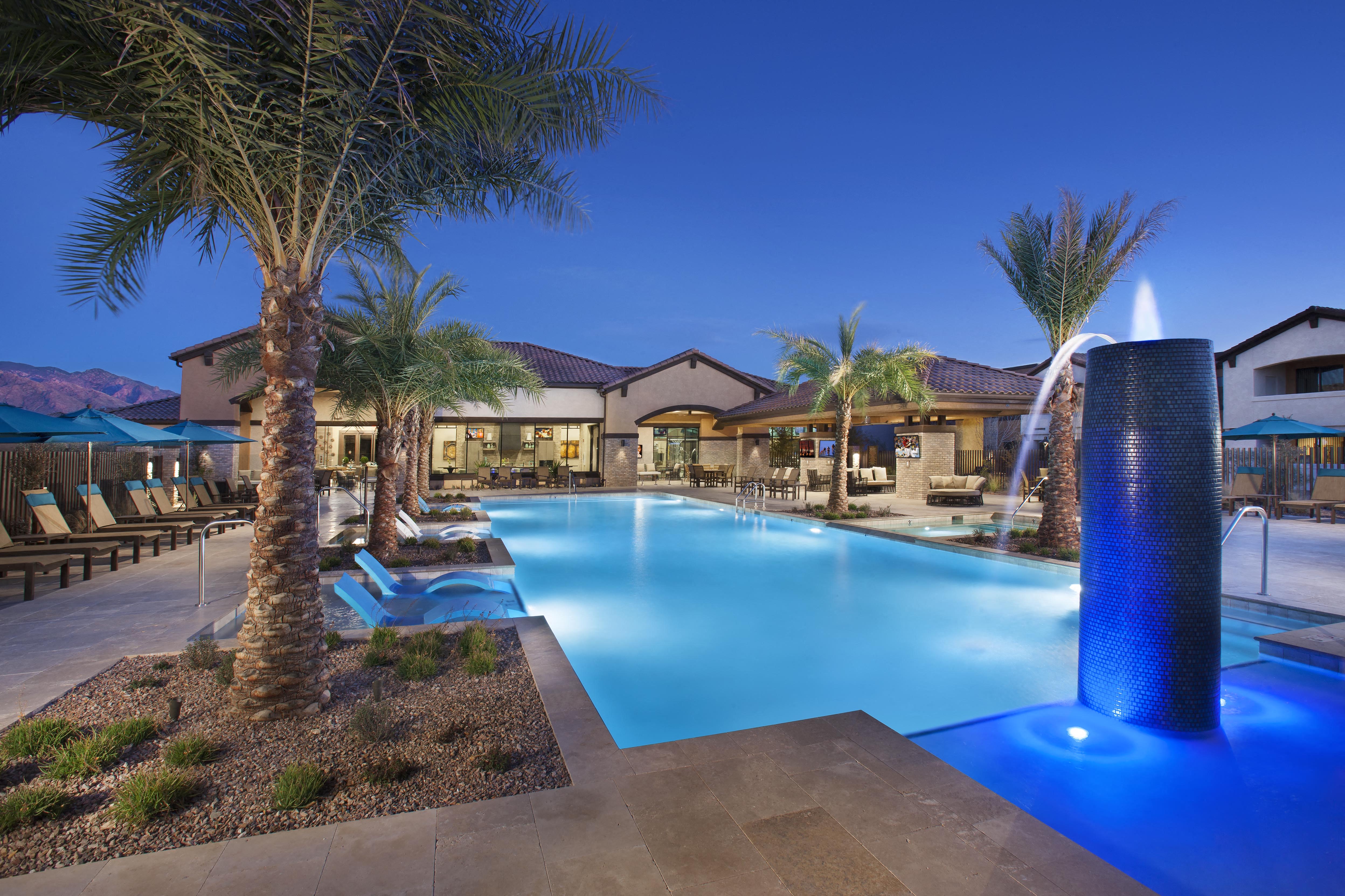 a swimming pool with palm trees and chairs around it