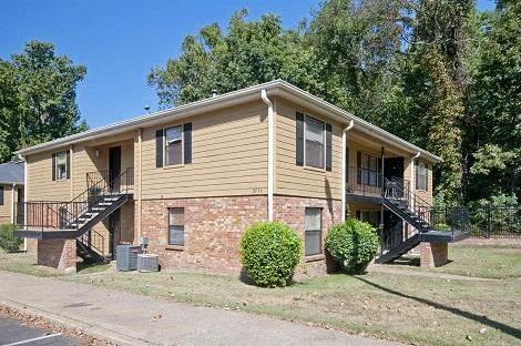 a yellow house with a porch and stairs