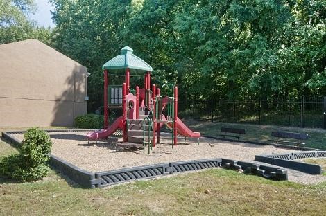 a childrens playground with a red swing set