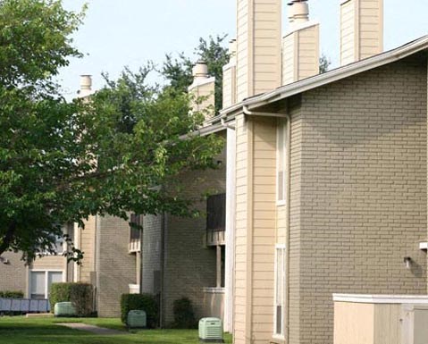 A building with a green lawn in front.