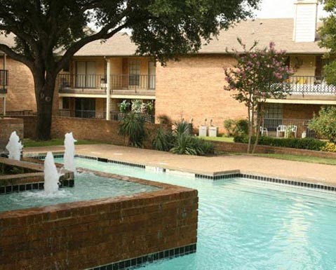 A pool with a fountain in the middle of it.