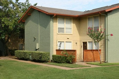 A house with a green siding and a brown fence.