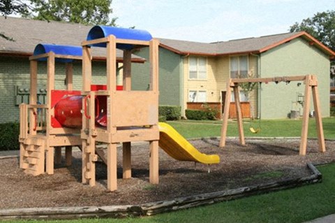 A wooden playground with a slide and a red and blue slide.