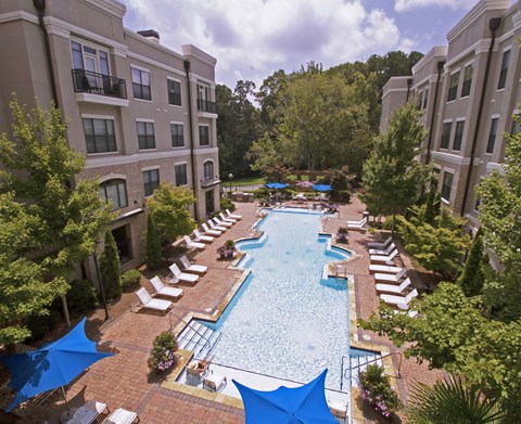 an aerial view of the resort style pool with lounge chairs and umbrellas