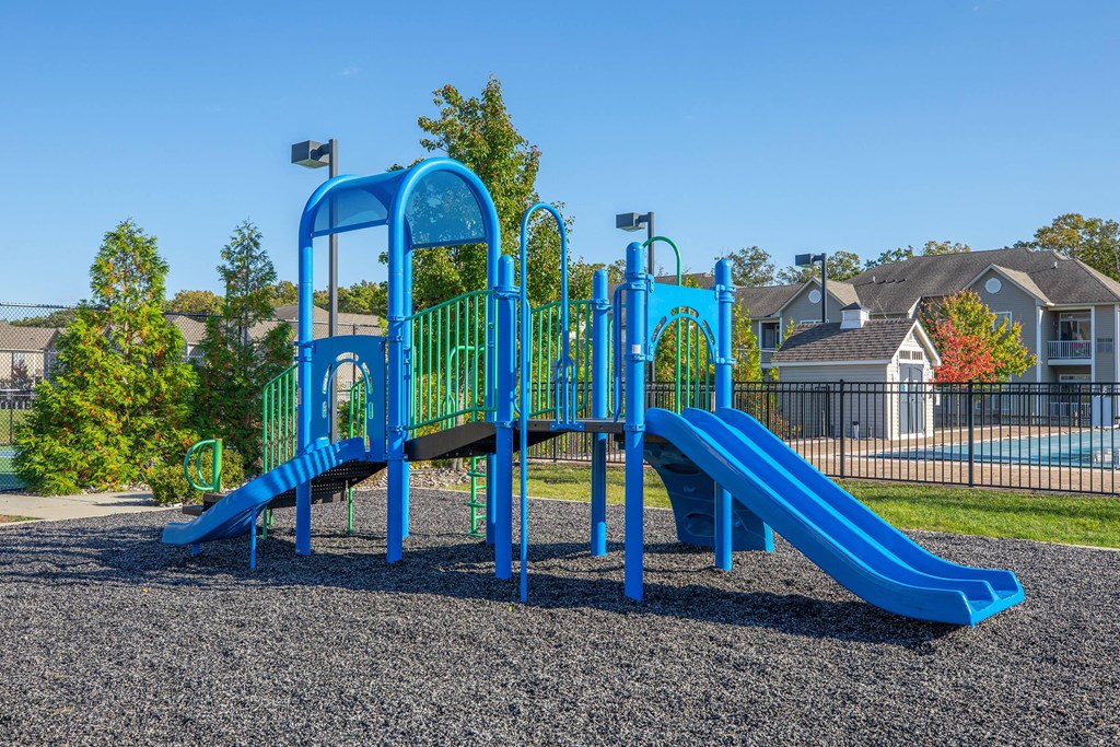 a playground with a blue slide at a park