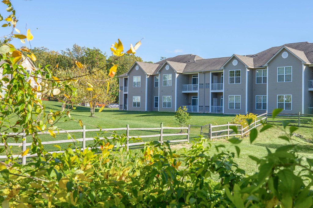 a view of an apartment building with a field in front of it