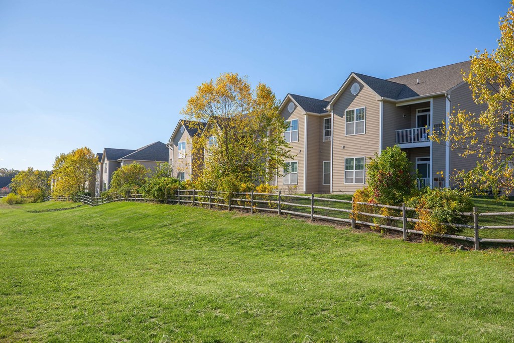 a group of houses on the side of a green field
