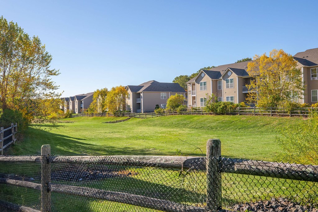 a view of an apartment complex from behind a fence