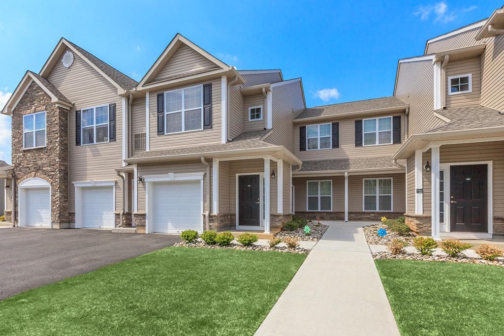 a row of houses with a sidewalk in front of them