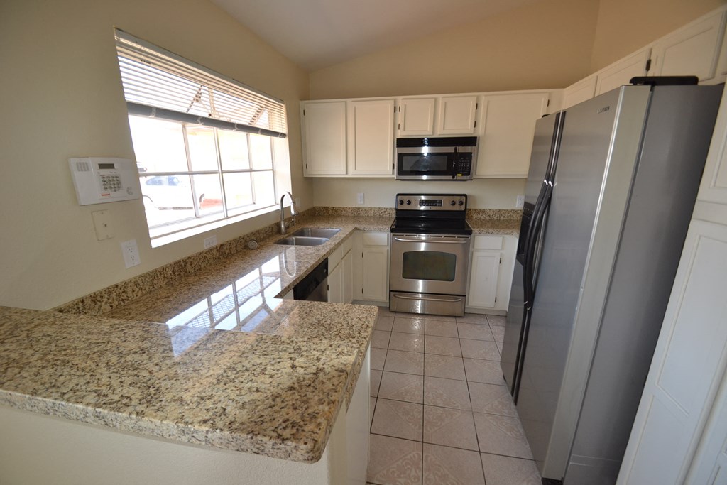 a kitchen with granite counter tops and stainless steel appliances