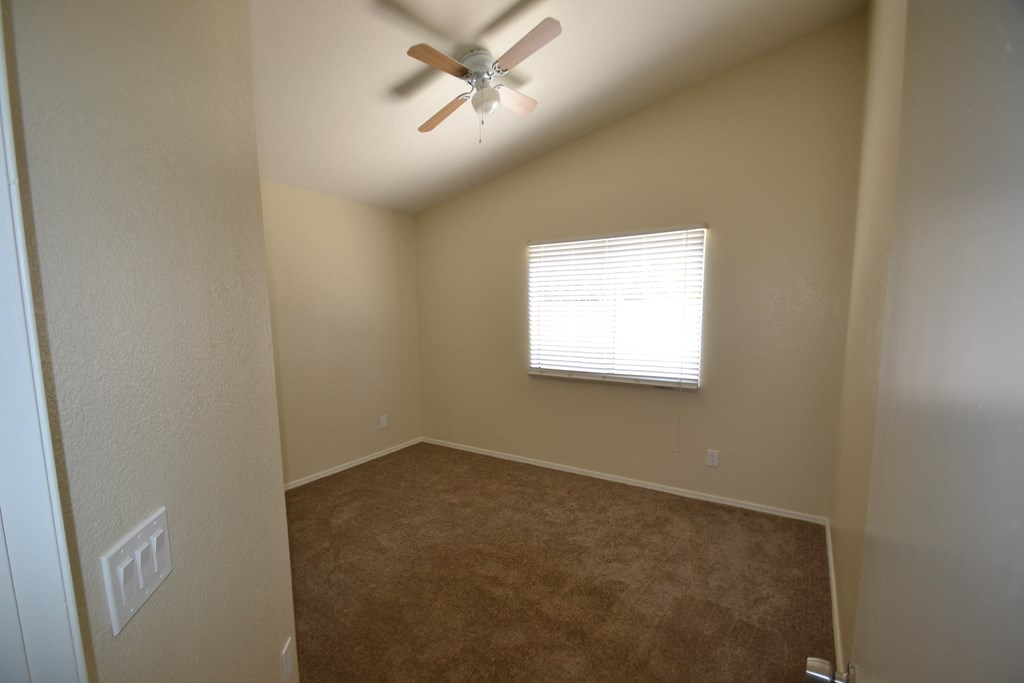 a bedroom with a ceiling fan and a window