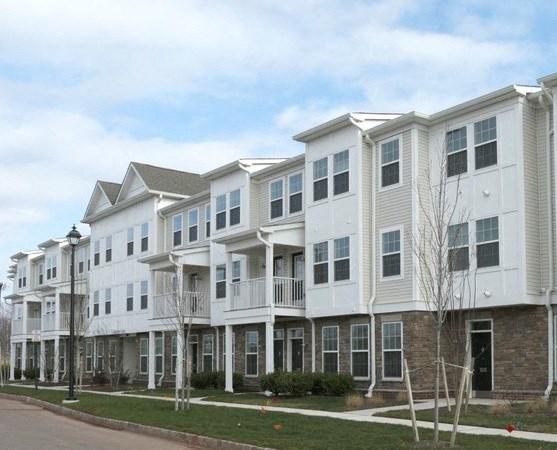 a row of white apartment buildings on the side of a street