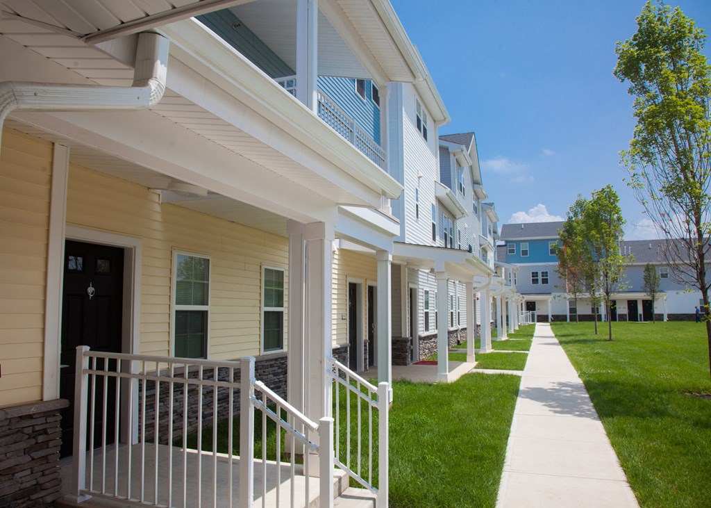 a row of houses with white railings and a sidewalk