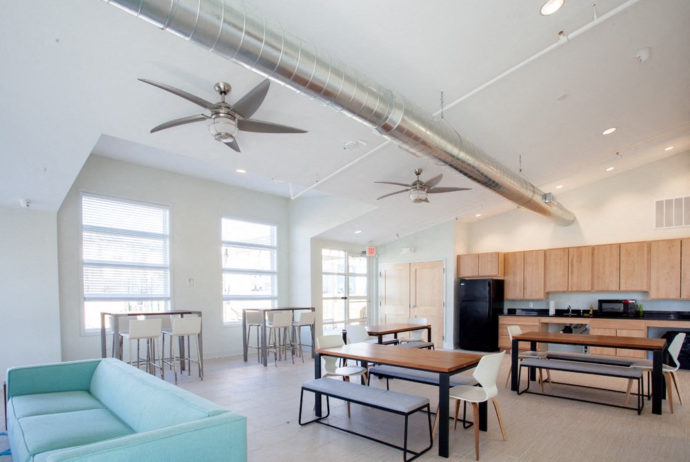a living room with couches and tables and a kitchen with a dining room table