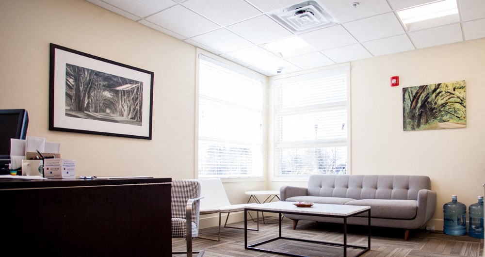 a living room with couches and chairs and a desk